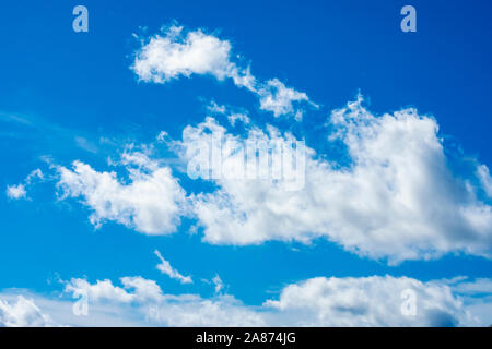 Dramatique nuages duveteux ensoleillée contre un ciel d'été bleu Banque D'Images
