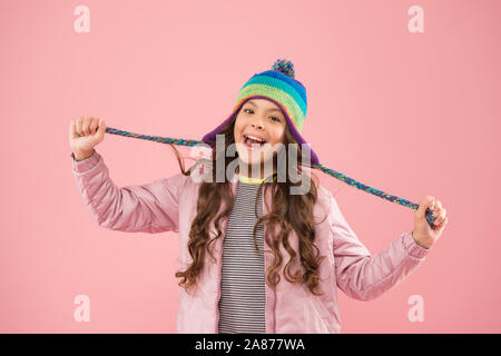 L'humeur ludique. Protéger la tête de l'accessoire. Adorable petit enfant tricoté usure accessoire. Cute little girl avec accessoire de mode fond rose. Accessoire élégant à la mode. Enfants chapeaux pour saison d'hiver. Banque D'Images