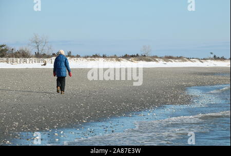 Old Lyme, CT / USA - 3 mars, 2019 : femme seule balade le long de la côte et faire de l'exercice malgré le froid Banque D'Images