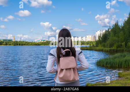 Fille brune avec un sac à dos offre une vue panoramique. Lac et paysage magnifique. L'aventure, la liberté, le mode de vie Banque D'Images