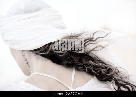 Femme avec de longs cheveux bouclés et foulard de derrière. High key image. Banque D'Images