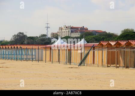 Cabines de plage fermée sur la célèbre plage du Lido à Venise, en basse saison, en octobre. Dans l'arrière-plan le Grand Hotel des Bains. L'Italie, l'Europe. Banque D'Images