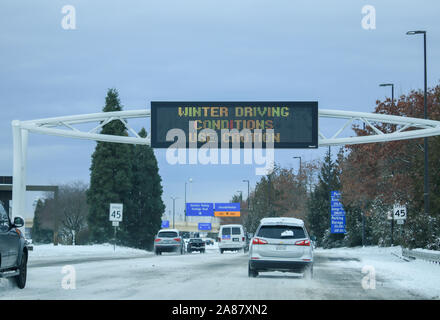 Les conditions routières en hiver, faites attention signe indiquant qu'il est dangereux de conduire sur les routes glacées et enneigées. Portland, Oregon USA / Février 2019. Banque D'Images