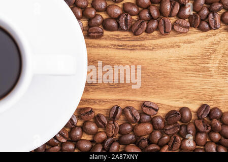 Grain de café. Sur l'arrière-plan de planches de bois une tasse de café et des grains de café. La mise en page. Mise à plat Banque D'Images