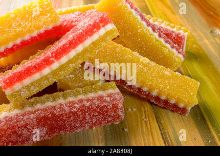 Marmelade de bonbons multicolores se trouvent dans pile sur fond de bois. Focus sélectif. Close-up. Banque D'Images