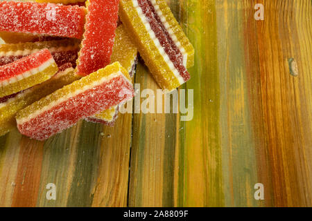 Marmelade de bonbons multicolores se trouvent dans pile sur fond de bois. Copier l'espace. Focus sélectif. Banque D'Images