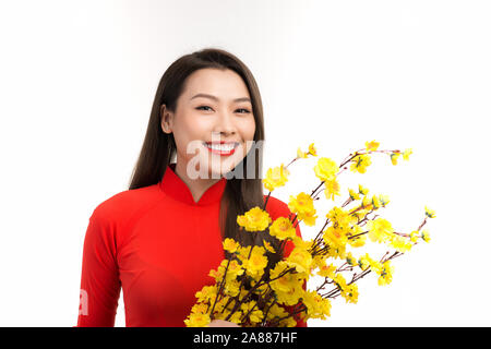 Charmante asian woman wearing ao dai avec abricot fleur jaune sur fond blanc. Banque D'Images