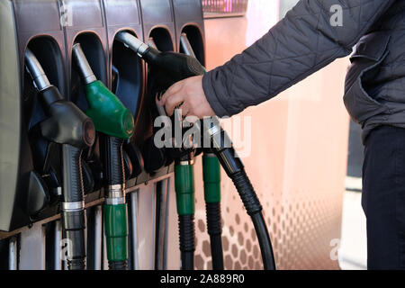 L'homme se remplit sa voiture avec l'essence à une station-service. La pompe à essence. Pour remplir sa voiture avec du carburant. L'essence et de produits pétroliers. Banque D'Images