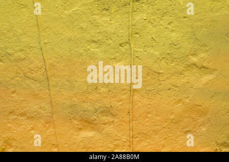 La texture d'un mur peint la plaque de ciment. fond de couleur jaune. mur avec bosses et petits trous. Banque D'Images