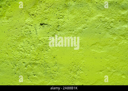 La texture d'un mur peint la plaque de ciment. couleur vert fond. mur avec bosses et petits trous. Banque D'Images