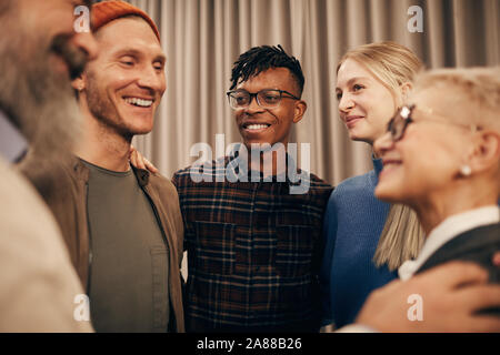 Groupe de personnes debout en souriant l'un à l'autre et de parler au cours de leur réunion Banque D'Images