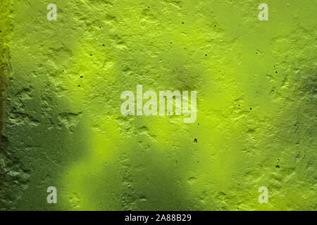 La texture du mur peint de façon inégale est vert clair. Le mur avec les irrégularités et fossettes. L'arrière-plan du livre vert mur de béton. Banque D'Images