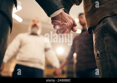 Close-up de gens debout et tenir la main pendant la formation en affaires au bureau Banque D'Images