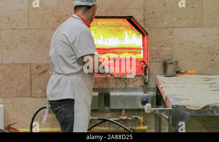 La cuisson du pain de façon traditionnelle dans un restaurant turc Banque D'Images