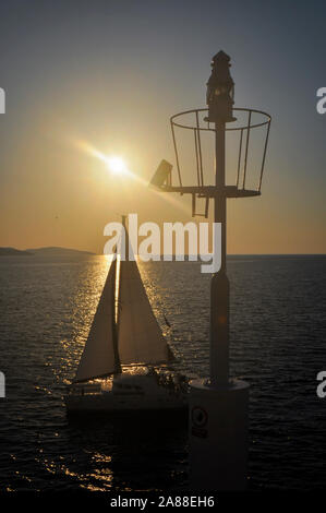 Catamaran saiing magnifique près de port balise sur journée ensoleillée pendant le coucher du soleil Banque D'Images