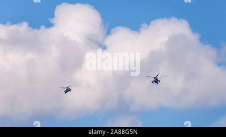 Deux hélicoptères militaires voler contre un beau ciel avec des nuages Banque D'Images