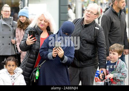 Diverses personnes regardant un marionnettiste. Un musulman en niqab. Banque D'Images