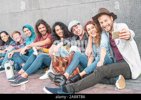 Professionnels divers les amis en tenant avec selfies smart mobile phone camera - jeunes millénaire s'amusant de faire des photos pour les nouvelles tendances du réseau social Banque D'Images