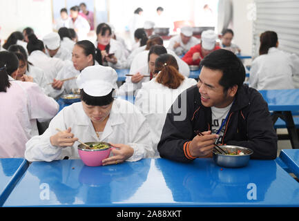 (191107) -- LINYI, 7 novembre 2019 (Xinhua) -- Caizhong Wu (R) et son épouse Pang Shuidi déjeuner dans une cantine de leur entreprise dans le comté de Linyi, Chine du Sud, région autonome Zhuang du Guangxi, le 6 novembre 2019. 205 de l'entreprise, les travailleurs sont déplacés de 71 ménages. Wu est un Caizhong 36 ans ethnique Mulao. Sa famille, avec d'autres personnes ethniques Mulao, utilisé pour vivre à Xiayantun de Mianhua Village, un village en proie à un développement inadéquat en raison de la désertification et les pauvres rocheuses karstiques des conditions de circulation. En juin 2018, la famille de Wu et d'autres villageois ont été déplacés vers un nouveau Banque D'Images