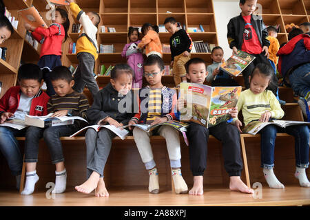 (191107) -- LINYI, 7 novembre 2019 (Xinhua) -- Wu Zihao (3R), le fils de Wu Caizhong, lit des livres avec ses camarades dans une école à Linyi County, Chine du Sud, région autonome Zhuang du Guangxi, le 6 novembre 2019. Wu est un Caizhong 36 ans ethnique Mulao. Sa famille, avec d'autres personnes ethniques Mulao, utilisé pour vivre à Xiayantun de Mianhua Village, un village en proie à un développement inadéquat en raison de la désertification et les pauvres rocheuses karstiques des conditions de circulation. En juin 2018, la famille de Wu et d'autres villageois ont été transférés dans une nouvelle zone résidentielle pour les personnes ethniques Mulao à Linyi. Ce résident Banque D'Images