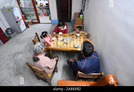 (191107) -- LINYI, 7 novembre 2019 (Xinhua) -- Caizhong Wu et sa famille ont le dîner dans leur nouvelle maison dans le comté de Linyi, Chine du Sud, région autonome Zhuang du Guangxi, le 6 novembre 2019. Wu est un Caizhong 36 ans ethnique Mulao. Sa famille, avec d'autres personnes ethniques Mulao, utilisé pour vivre à Xiayantun de Mianhua Village, un village en proie à un développement inadéquat en raison de la désertification et les pauvres rocheuses karstiques des conditions de circulation. En juin 2018, la famille de Wu et d'autres villageois ont été transférés dans une nouvelle zone résidentielle pour les personnes ethniques Mulao à Linyi. Cette zone résidentielle, avec multipl Banque D'Images