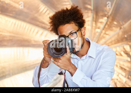 Jeune photographe ou étudiant photo photographiant en studio Banque D'Images