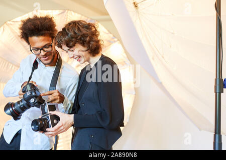 Deux photographes photographes ou de comparer leurs modèles d'appareil photo Banque D'Images