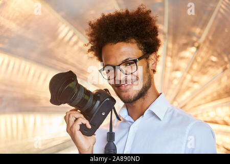 Jeune photographe avec appareil photo reflex dans le studio photo Banque D'Images