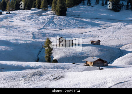 Belle vue sur la montagne chalets traditionnels en bois sur Scenic Alpe di Siusi célèbre Langkofel avec des pics de montagne dans l'arrière-plan dans la matinée d'or Banque D'Images