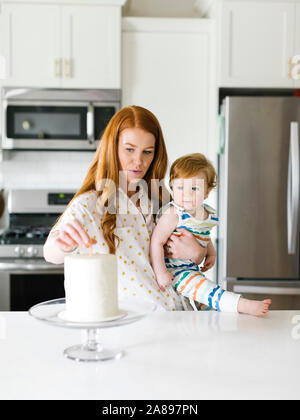 Mère et bébé garçon par gâteau d'anniversaire Banque D'Images