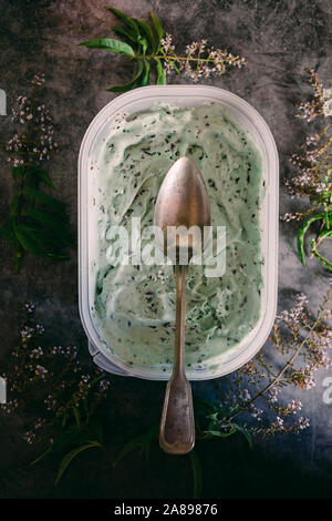 Versez la crème glacée au chocolat à la menthe avec des fleurs Banque D'Images