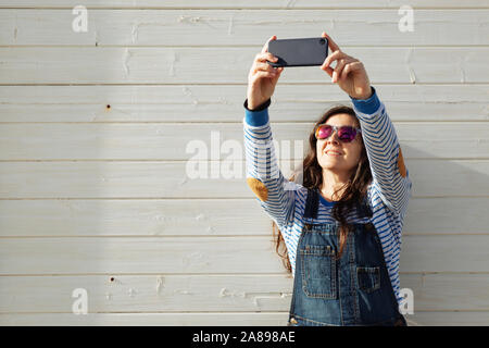 Femme portant des lunettes de soleil prendre selfies Banque D'Images