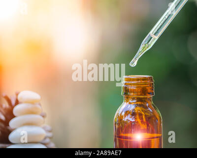 L'huile essentielle relevant du compte-gouttes en verre organique en bio la médecine alternative, bouteille brune. Banque D'Images