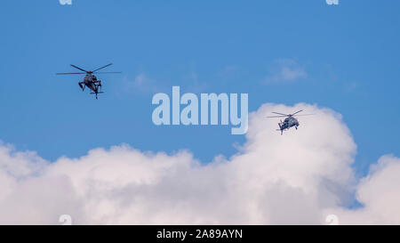 Deux hélicoptères militaires voler contre un beau ciel avec des nuages Banque D'Images