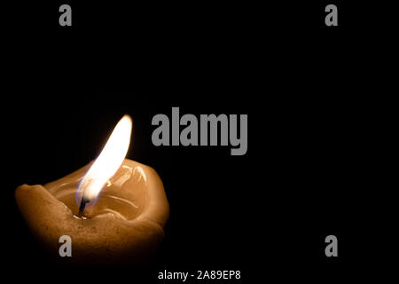 Lonely bougie commémorative. Flamme de bougie brûle dans le noir Banque D'Images