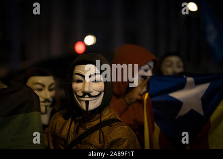 Les membres de la Catalogne anonyme et les partisans de Julian Assange portant des masques de démontrer au cours de millions d'Mask mars à Barcelone. Banque D'Images