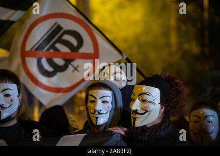 Les membres de la Catalogne anonyme et les partisans de Julian Assange portant des masques de démontrer au cours de millions d'Mask mars à Barcelone. Banque D'Images