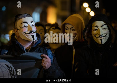 Les membres de la Catalogne anonyme et les partisans de Julian Assange portant des masques de démontrer au cours de millions d'Mask mars à Barcelone. Banque D'Images