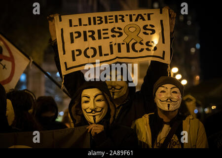 Les membres de la Catalogne anonyme et les partisans de Julian Assange portant des masques de démontrer au cours de millions d'Mask mars à Barcelone. Banque D'Images