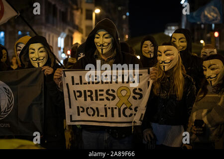 Les membres de la Catalogne anonyme et les partisans de Julian Assange portant des masques de démontrer au cours de millions d'Mask mars à Barcelone. Banque D'Images