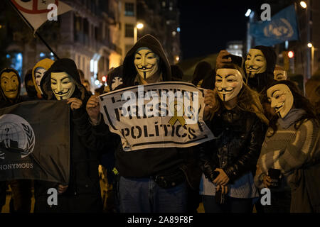 Les membres de la Catalogne anonyme et les partisans de Julian Assange portant des masques de démontrer au cours de millions d'Mask mars à Barcelone. Banque D'Images