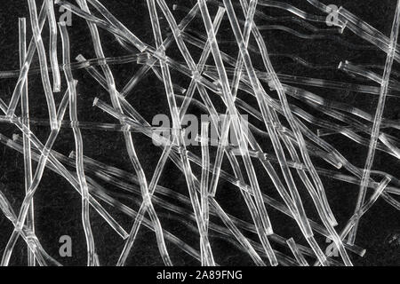 Extreme close up, de haut en bas vue de fibres macro sertis en polypropylène pour le renforcement du béton sur fond noir en noir. L'industrie de la construction Banque D'Images