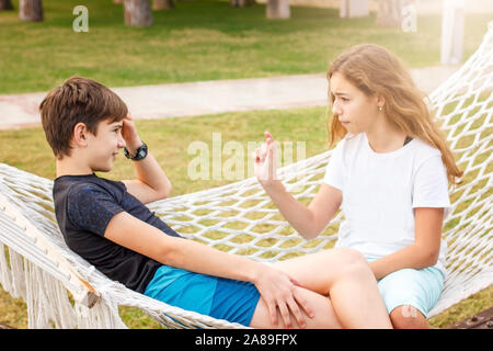 Couple de jeunes professionnels des adolescents. Fille et garçon parler à l'extérieur chat hamac Banque D'Images