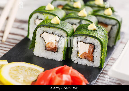 Cuisine japonaise traditionnelle. Des sushis au saumon et au fromage sont prêts à être servis. Délicieux plats japonais. Banque D'Images