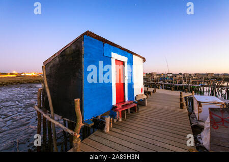 Une cabane de pêcheur sur un des piliers de bois jetée, le port de pêche de palafite Carrasqueira au crépuscule. Alentejo, Portugal Banque D'Images