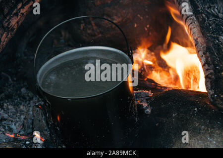 Pot touristique au-dessus du feu. Dans la cuisine de cuisson en aluminium. Survie dans la nature. Banque D'Images