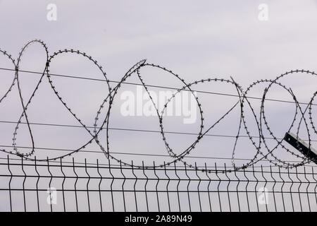 Du fil de fer barbelé contre le ciel nuageux. Les clôtures de fil barbelé clôture de la prison. Le concept de captivité, l'esclavage, les prisonniers, les condamnés. Prison, checkp Banque D'Images