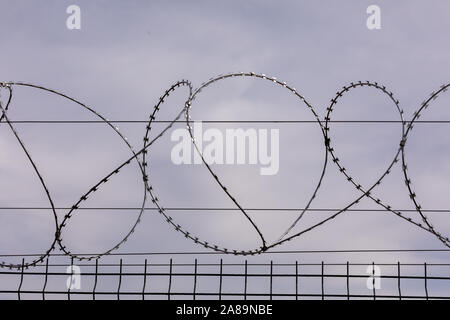 Du fil de fer barbelé contre le ciel nuageux. Les clôtures de fil barbelé clôture de la prison. Le concept de captivité, l'esclavage, les prisonniers, les condamnés. Prison, checkp Banque D'Images