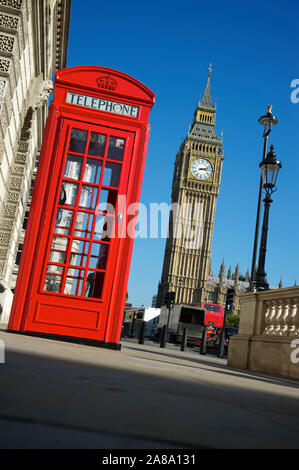 Boîte de téléphone rouge anglais iconique se tient à côté d'un ciel bleu vue de Big Ben à Londres, au Royaume-Uni avec une inclinaison funky Banque D'Images