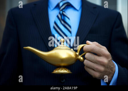 Méconnaissable businessman holding golden lampe magique en attente d'une frotter pour faire ressortir le génie d'accorder trois voeux Banque D'Images